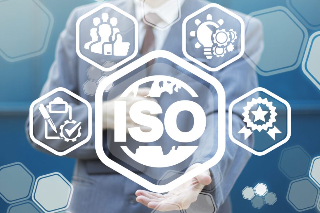 A man in a suit and tie holding out an iso sign.