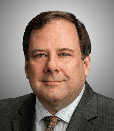 A man in suit and tie smiling for the camera.